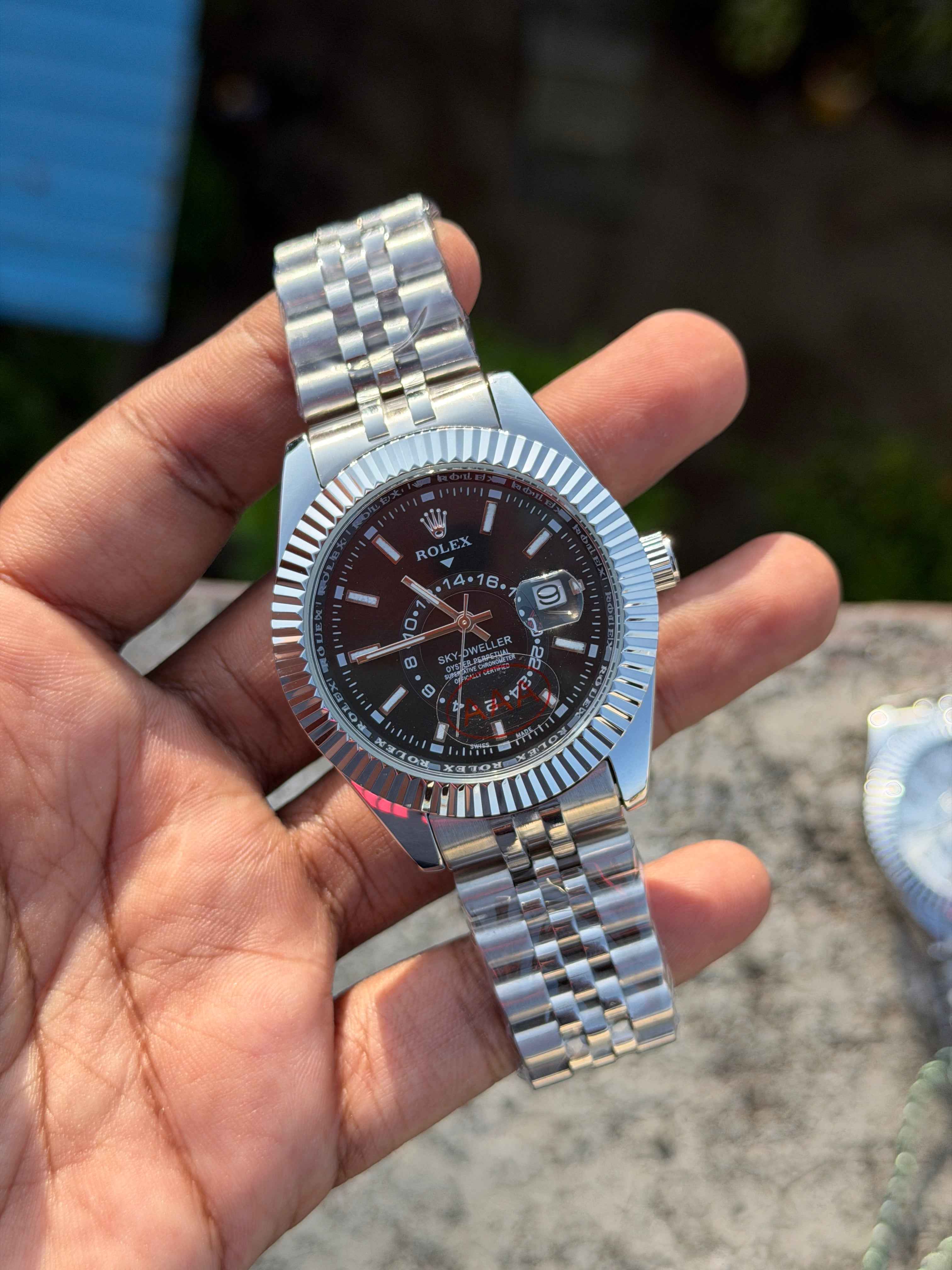 Rolex Sky-Dweller watch features a prominent fluted bezel and a black dial.
