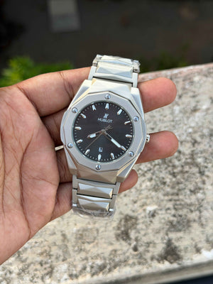 Hublot-style watch with a silver-tone stainless steel integrated bracelet and black dial.