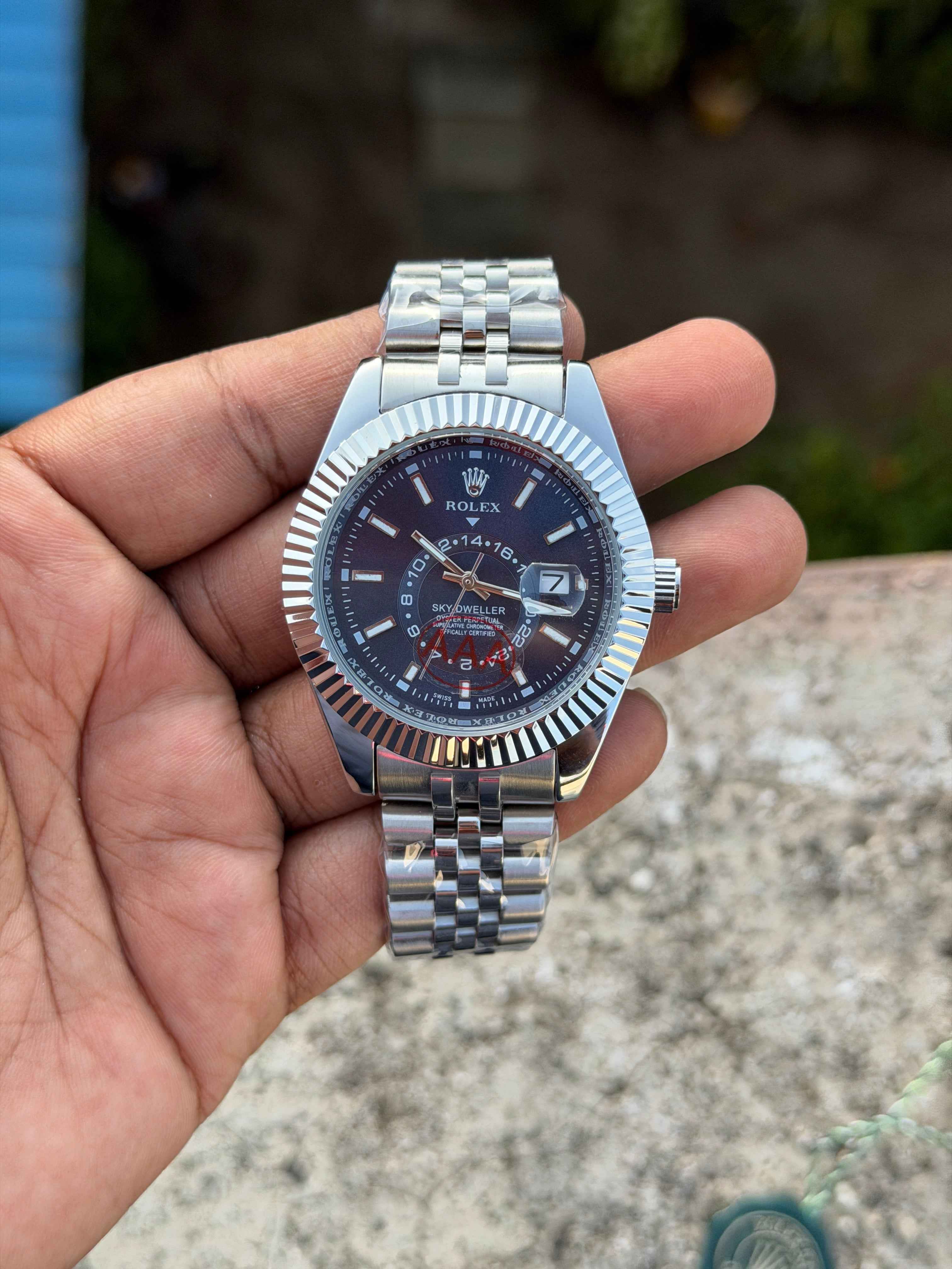 This Rolex Sky-Dweller features a prominent fluted bezel and a blue dial with a 24-hour display disc.