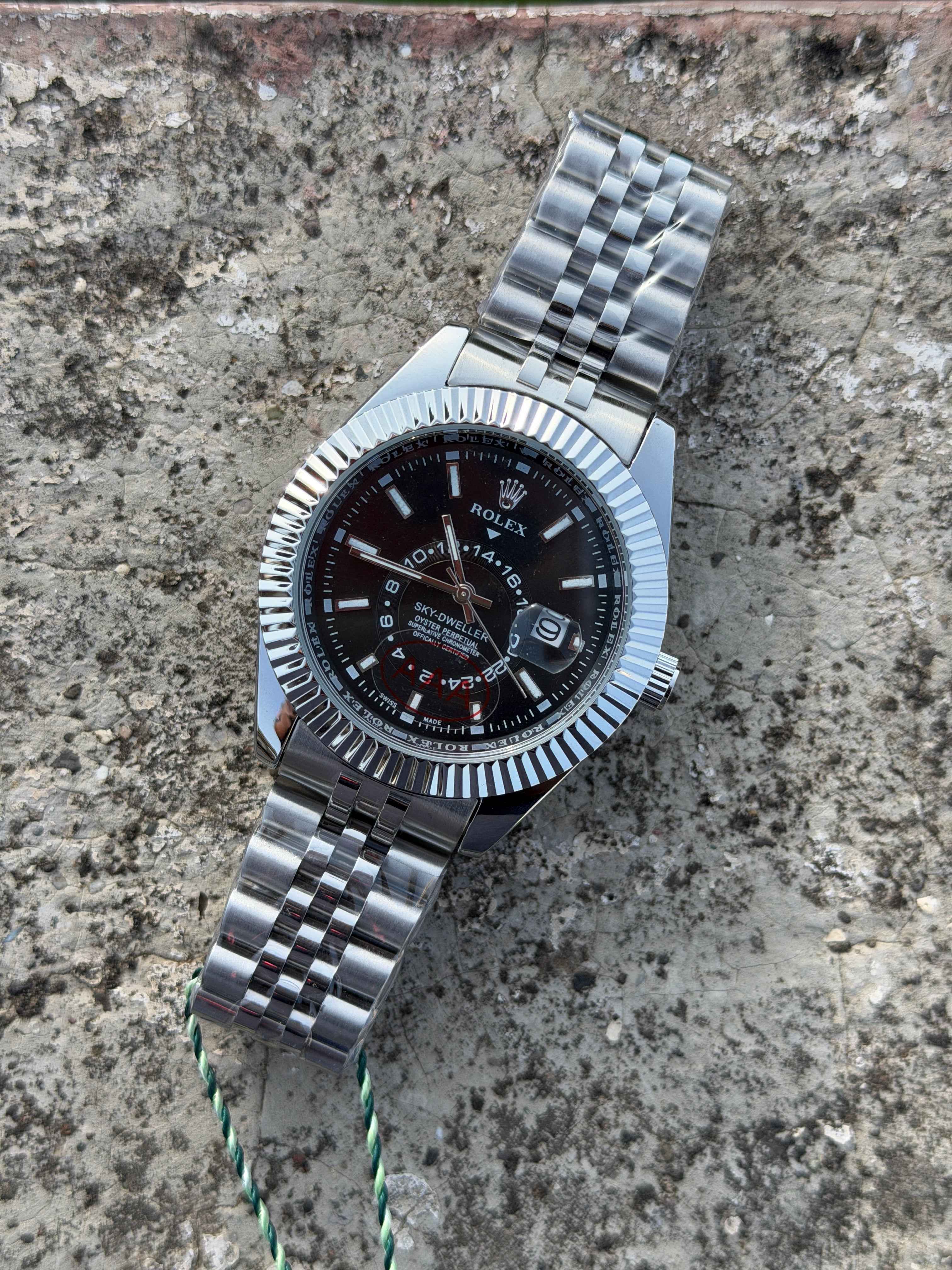 Rolex Sky-Dweller watch features a prominent fluted bezel and a black dial.